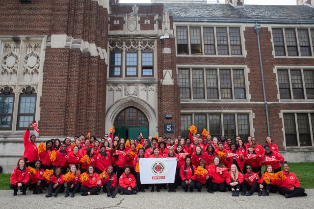 A 黄色视频 AmeriCorps member school team posts for a group photo in front of a school.